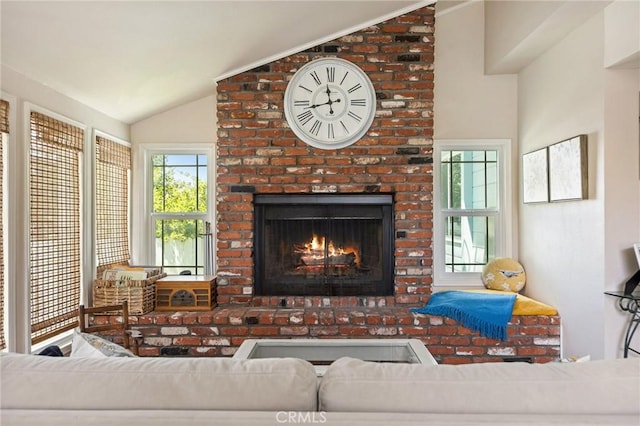 living room with a brick fireplace and vaulted ceiling