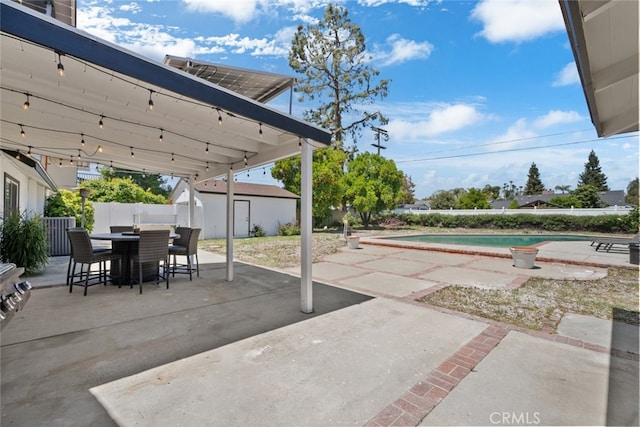 17441 Rayen St, Sherwood Forest, CA 91325 - view of patio featuring a fenced in pool, fence, an outbuilding, and outdoor dining space