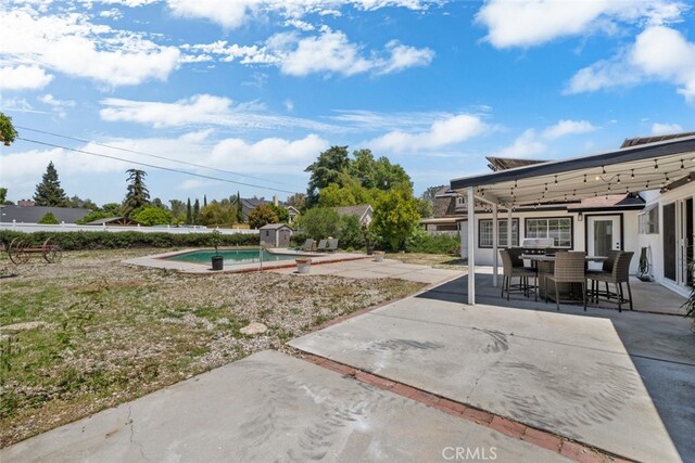 17441 Rayen St, Sherwood Forest, CA 91325 - view of patio featuring an outdoor pool, an outdoor structure, outdoor dining space, and a storage unit