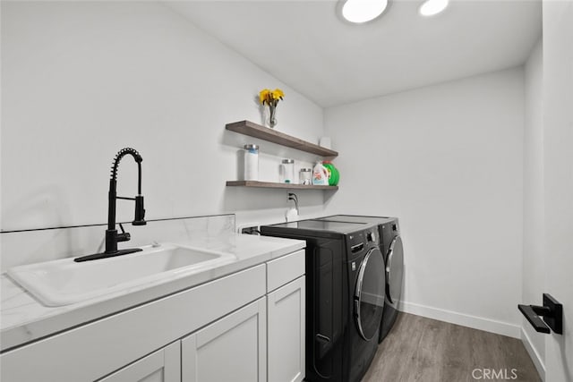 17441 Rayen St, Sherwood Forest, CA 91325 - clothes washing area with cabinet space, a sink, light wood finished floors, separate washer and dryer, and baseboards