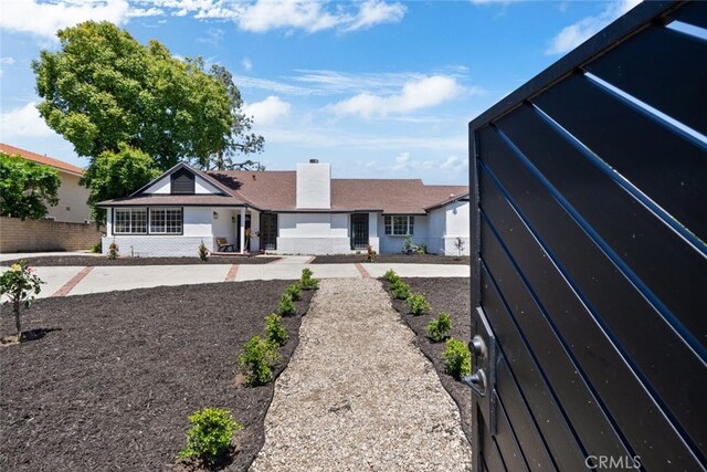 17441 Rayen St, Sherwood Forest, CA 91325 - back of house with fence, a chimney, and brick siding