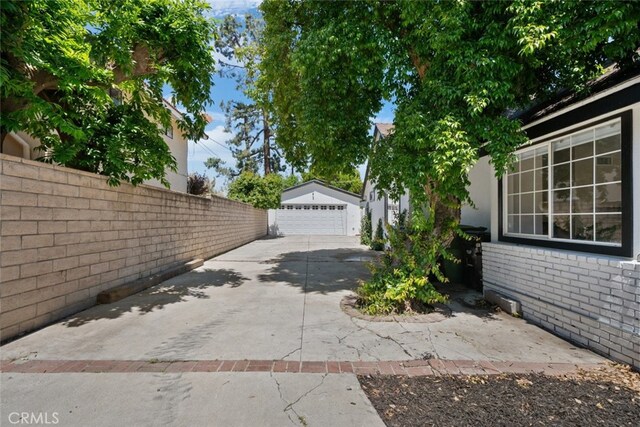 17441 Rayen St, Sherwood Forest, CA 91325 - view of home's exterior featuring fence, brick siding, a detached garage, an outbuilding, and driveway