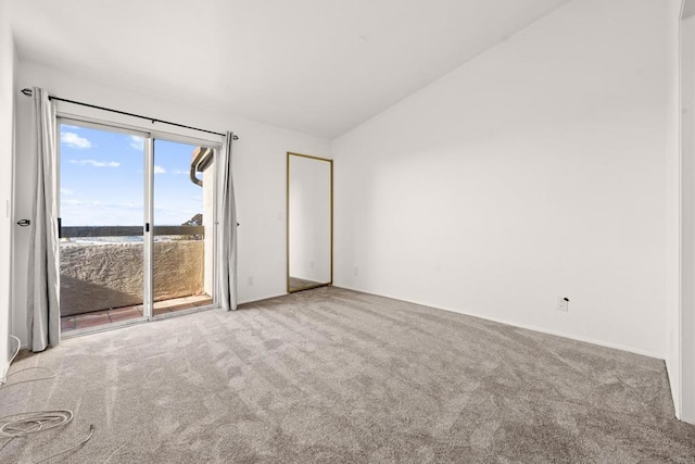 unfurnished room featuring vaulted ceiling and carpet