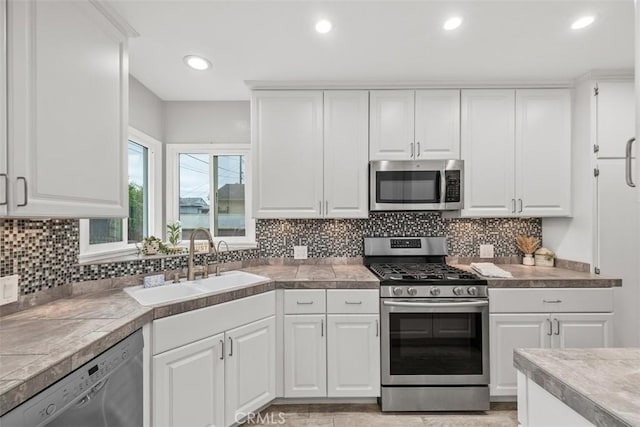 18012 Falda Ave, Torrance, CA 90504 - kitchen featuring a sink, backsplash, white cabinets, and stainless steel appliances