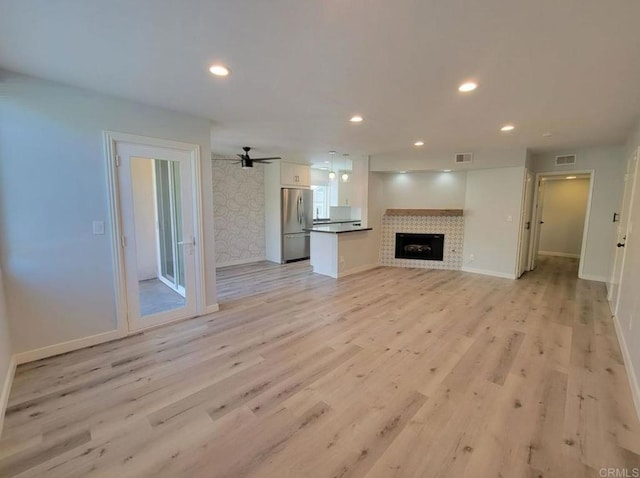 unfurnished living room featuring visible vents, recessed lighting, baseboards, and light wood-type flooring