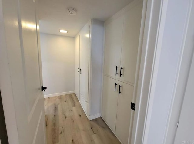 hallway with baseboards and light wood finished floors