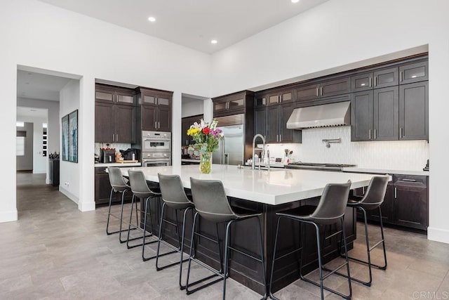 3881 Rancho Summit Dr, Encinitas, CA 92024 - kitchen with extractor fan, appliances with stainless steel finishes, light countertops, decorative backsplash, and glass insert cabinets