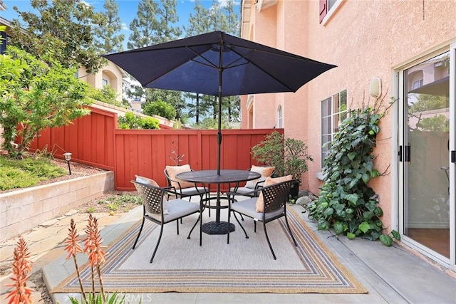 view of patio featuring fence and outdoor dining area