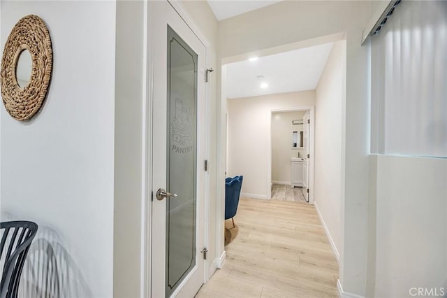 hallway featuring recessed lighting, baseboards, and light wood finished floors