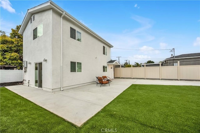 rear view of property with a yard, a patio, fence, and stucco siding