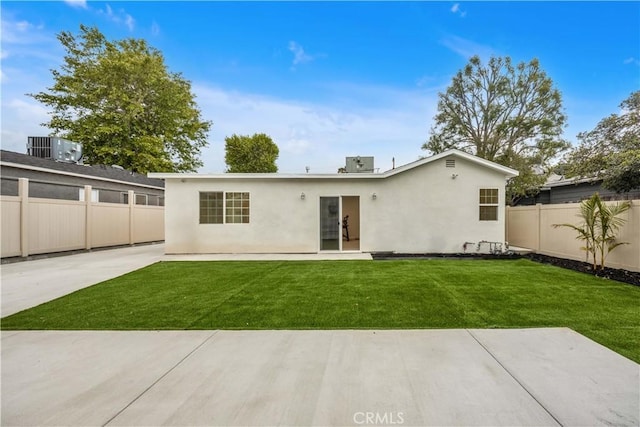 back of house featuring a fenced backyard, a patio, stucco siding, and a yard
