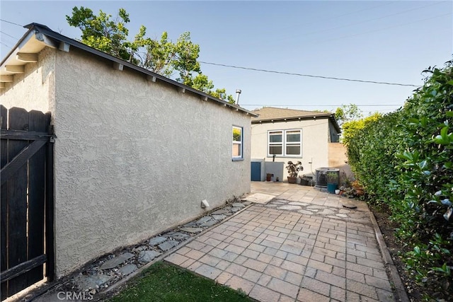 exterior space featuring fence, a patio area, and stucco siding