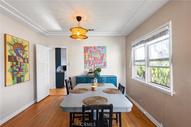 dining space with baseboards and wood finished floors