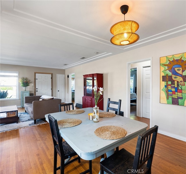dining room with baseboards, wood finished floors, and visible vents