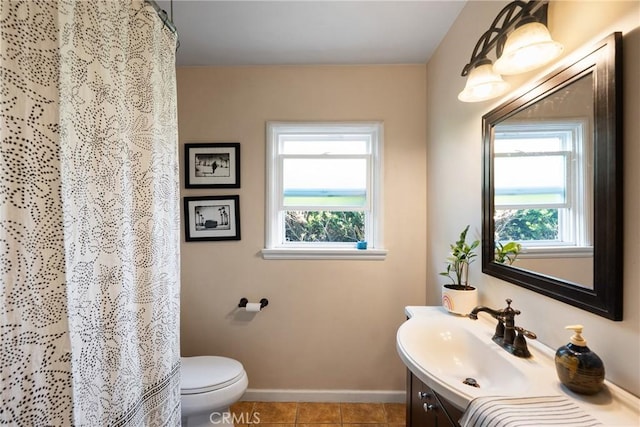bathroom featuring plenty of natural light, baseboards, toilet, and vanity