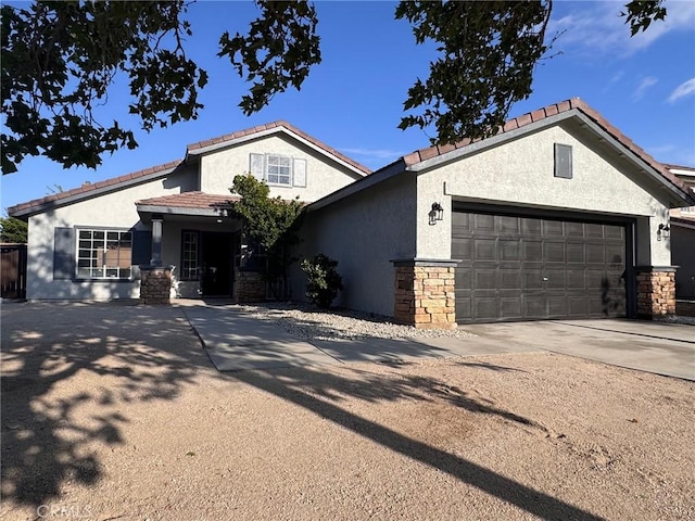 view of front of property with concrete driveway, an attached garage, stucco siding, and stone siding