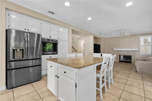 4677 Willow Bend Ct, Chino Hills, CA 91709 - kitchen featuring white cabinets, light stone counters, stainless steel appliances, a kitchen bar, and ornamental molding