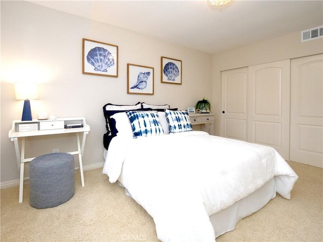 carpeted bedroom featuring baseboards, a closet, and visible vents