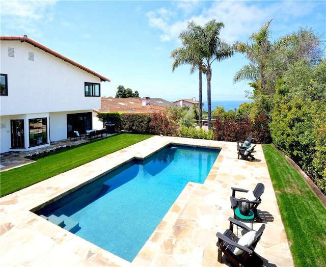 view of pool featuring a lawn, a fenced in pool, and a patio area