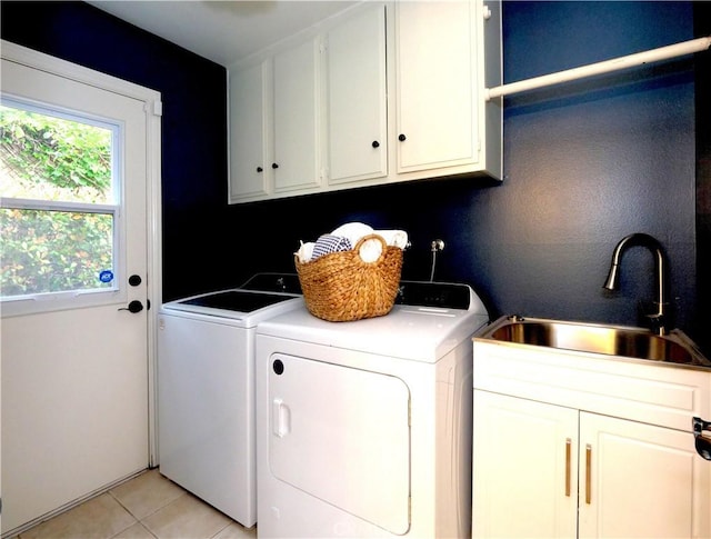 laundry room with a sink, light tile patterned floors, cabinet space, and washer and clothes dryer
