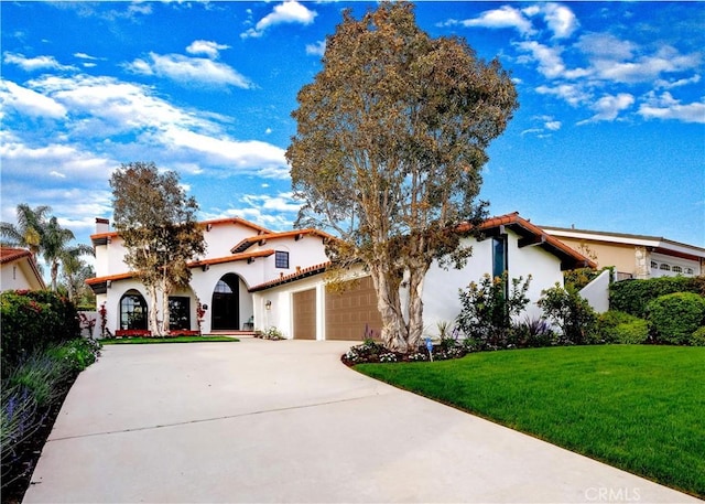mediterranean / spanish-style house featuring a garage, driveway, a front lawn, and stucco siding