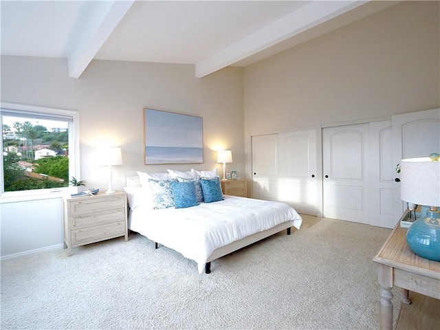 bedroom featuring multiple closets, vaulted ceiling with beams, and light carpet