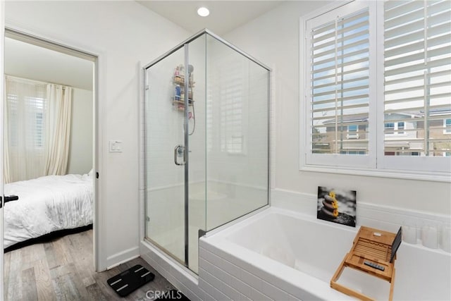 bathroom featuring a shower stall, a bath, and wood finished floors
