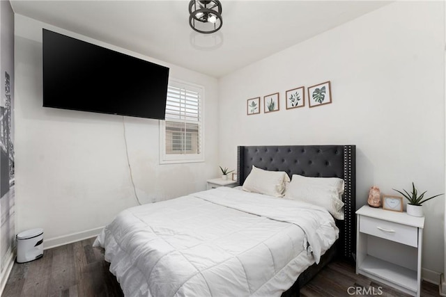 bedroom with baseboards and wood finished floors