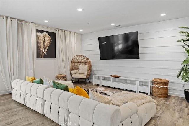 living area with recessed lighting, wood finished floors, and visible vents