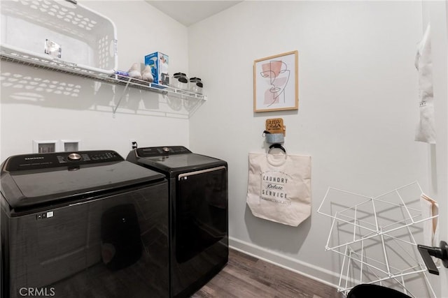 laundry area with baseboards, laundry area, washer and clothes dryer, and wood finished floors