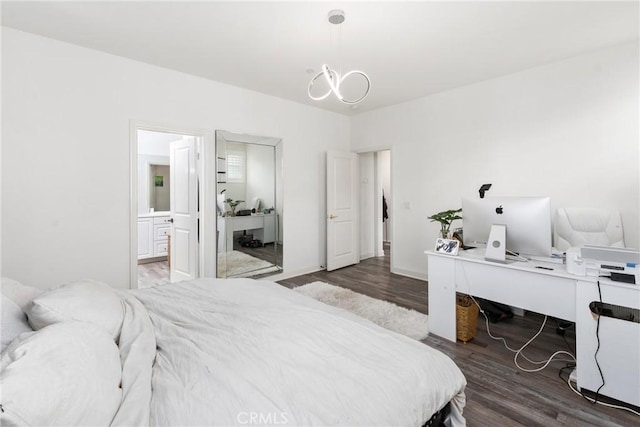 bedroom with ensuite bath, wood finished floors, and a notable chandelier