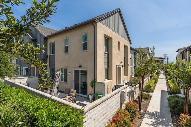back of property featuring fence and stucco siding