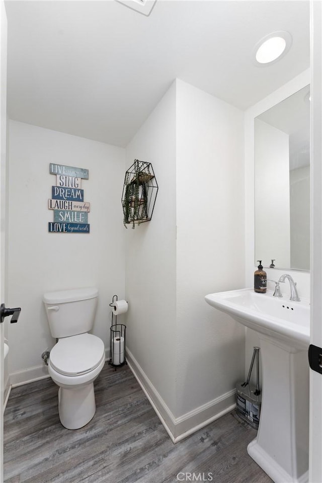 bathroom featuring baseboards, toilet, and wood finished floors