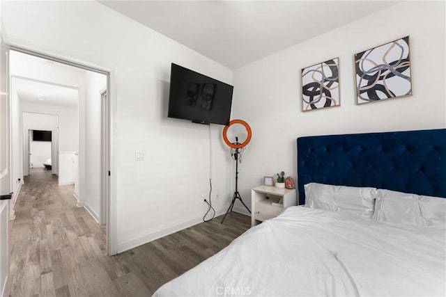 bedroom featuring baseboards and wood finished floors