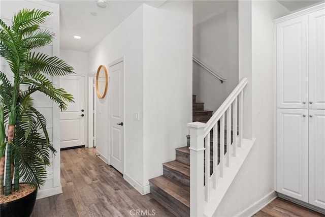 stairs with baseboards, recessed lighting, and wood finished floors