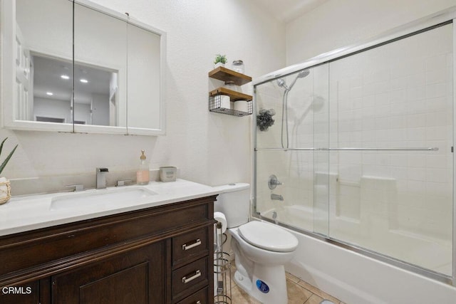 full bath with vanity, shower / bath combination with glass door, tile patterned flooring, and toilet