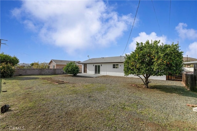 back of house with a lawn, a fenced backyard, and a patio area