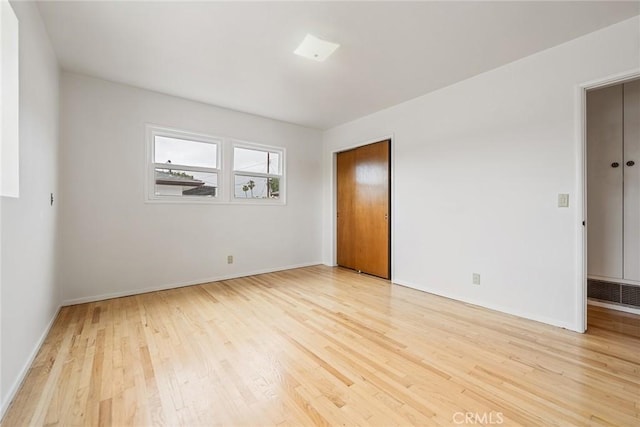 unfurnished bedroom with wood finished floors and baseboards
