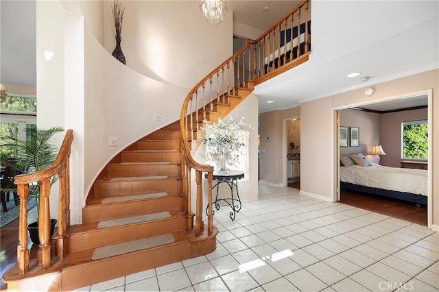 16562 Orangewind Ln, Riverside, CA 92503 - stairway with tile patterned flooring, crown molding, a high ceiling, a chandelier, and baseboards