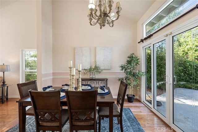 16562 Orangewind Ln, Riverside, CA 92503 - dining area with high vaulted ceiling, a chandelier, wood finished floors, and baseboards