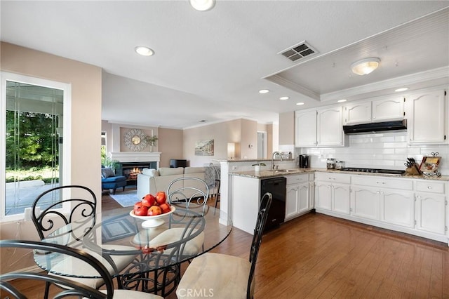 16562 Orangewind Ln, Riverside, CA 92503 - kitchen with black appliances, a peninsula, white cabinets, a sink, and under cabinet range hood