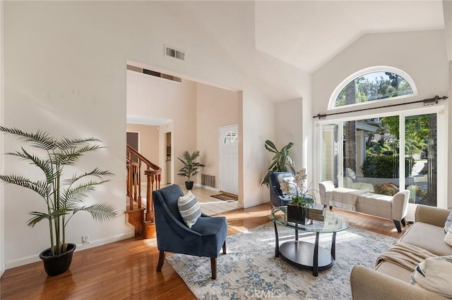 16562 Orangewind Ln, Riverside, CA 92503 - living room with high vaulted ceiling, stairway, and light wood-style flooring
