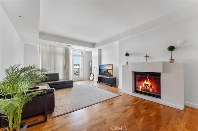 920 Granite Dr Unit 502, Pasadena, CA 91101 - living room featuring baseboards, a tray ceiling, a glass covered fireplace, and wood finished floors