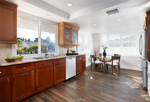 kitchen with visible vents, crown molding, dishwashing machine, a sink, and backsplash