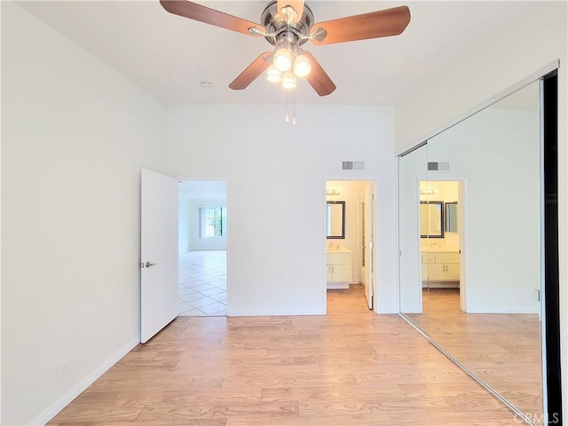 unfurnished bedroom featuring visible vents, connected bathroom, and light wood-type flooring