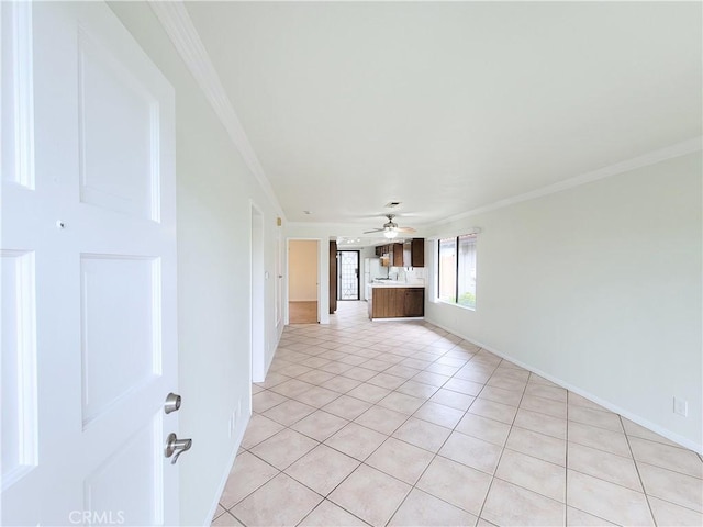 unfurnished living room with baseboards, ornamental molding, light tile patterned flooring, and ceiling fan