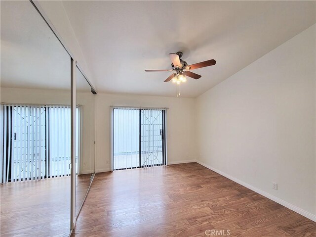 unfurnished room featuring ceiling fan, baseboards, and wood finished floors