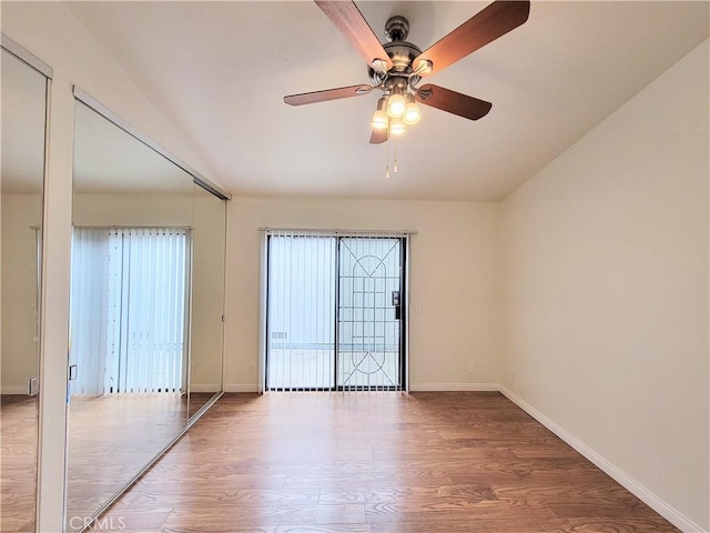 spare room featuring baseboards, ceiling fan, and wood finished floors