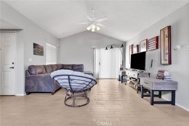 living room featuring a healthy amount of sunlight, ceiling fan, vaulted ceiling, and light wood-type flooring