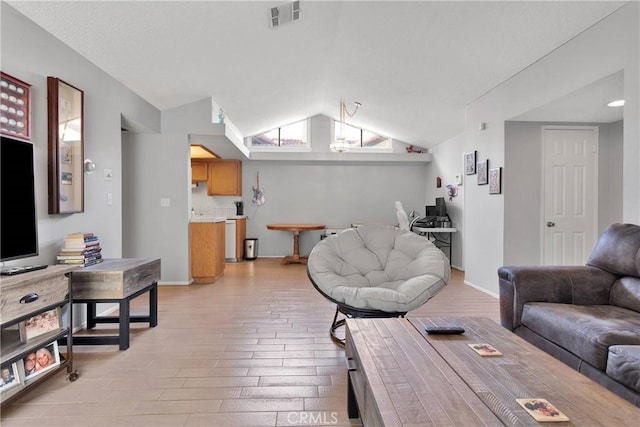 living room with baseboards, visible vents, lofted ceiling, and light wood-type flooring